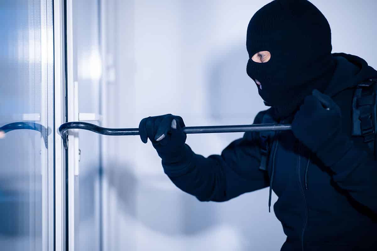Einbrecher mit Brechstange versucht eine Terassentür zu öffnen